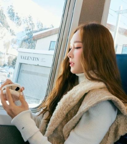 31岁郑秀妍旅行照，白色毛衣+棕色毛绒马甲，优雅大气庄重十足