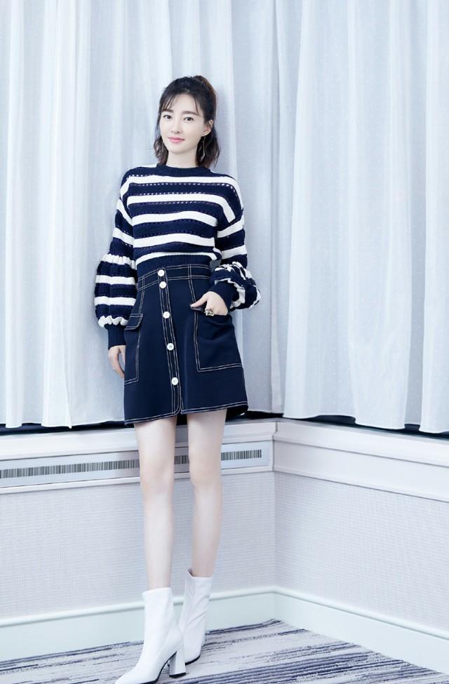 王丽坤蕴藏设计巧思的条纹镂空毛衣，搭配牛仔半身裙凸显酷萌特质