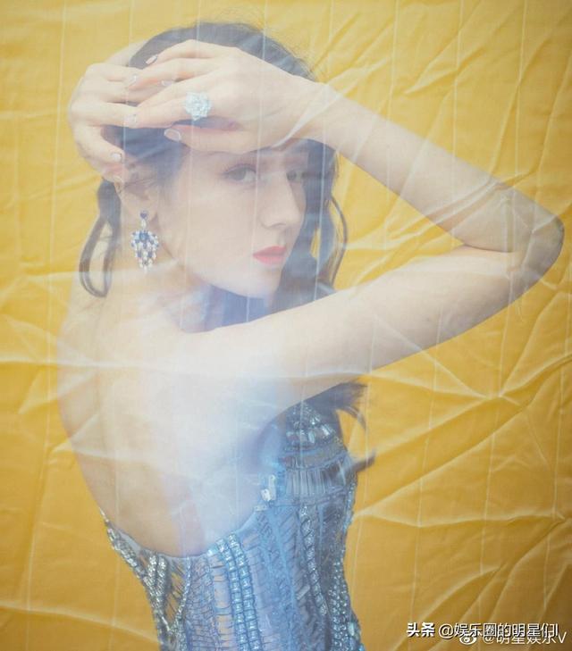 迪丽热巴穿水蓝色抹胸纱裙拍写真照，星星点点尽显妩媚娇艳。