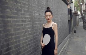 37岁王鸥在胡同街拍，穿黑色吊带手持宣纸扇，肤白妆酷气质惊艳
