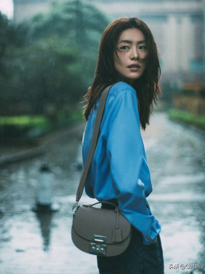 刘雯身穿蓝色衬衫搭配牛仔裤，漫步在雨中，清新悠闲时尚好看