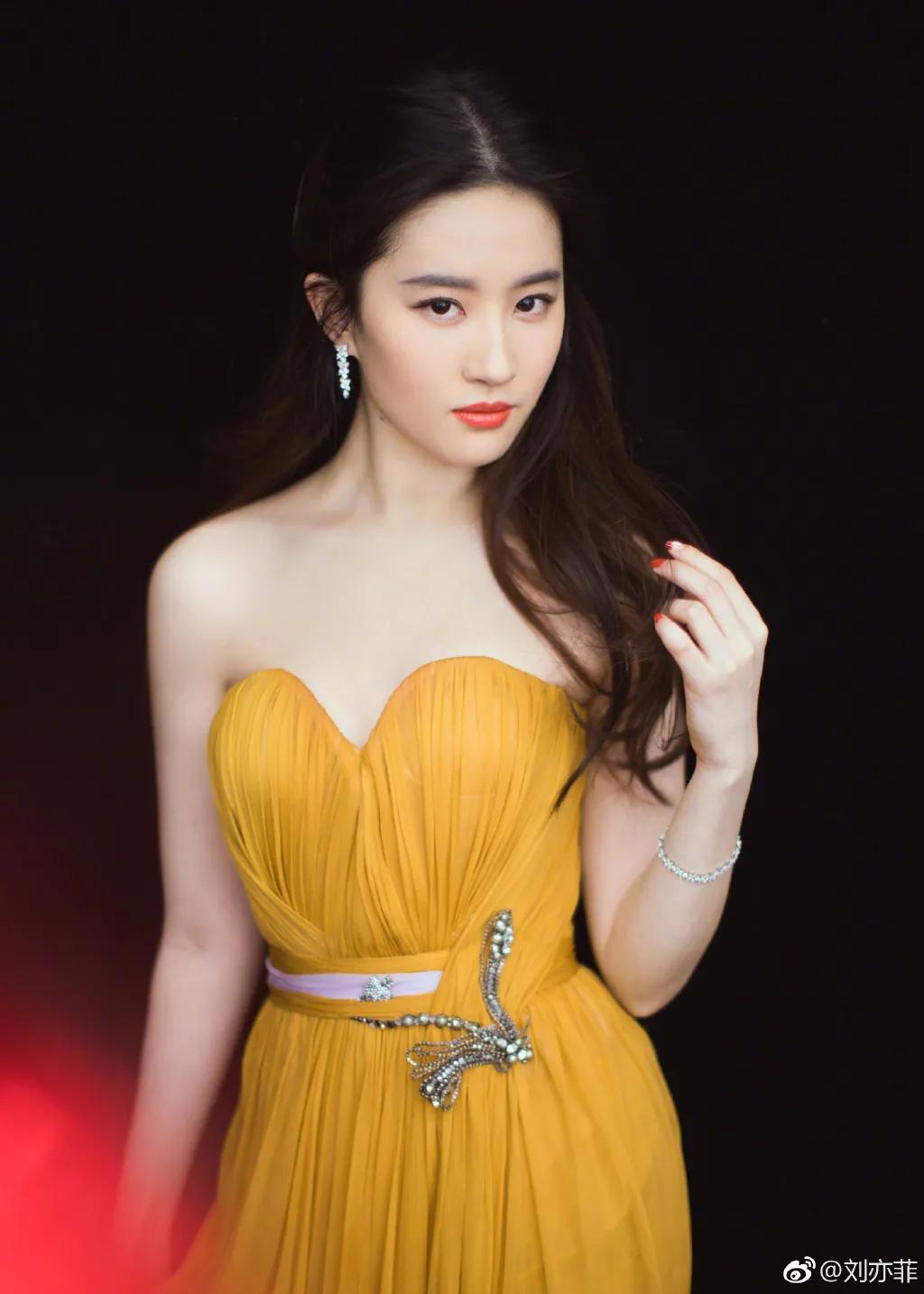 刘亦菲 穿着黄色抹胸纱裙 一头柔顺的长发披在肩头 尽显柔美气质