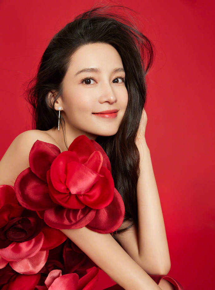 李沁发布了一组春节写真，身穿一袭红花形状的红色露肩衣裙，微微一笑很倾城